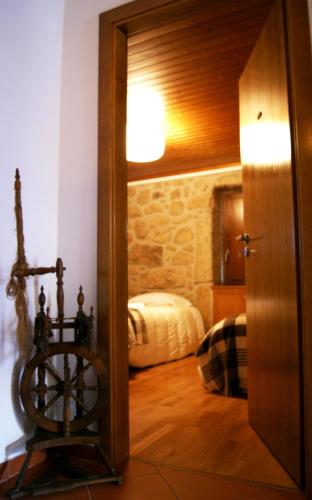 a room with a door leading to a bedroom with a bed at Cantinho Santiago in Belmonte