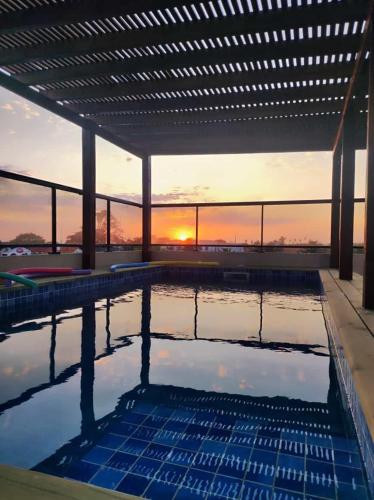 a swimming pool with a sunset in the background at Hotel Bahia in La Paloma