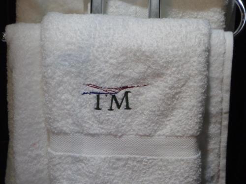 Una toalla blanca con la palabra "im" en ella. en Casa do Ti Latoeiro en Torre de Moncorvo
