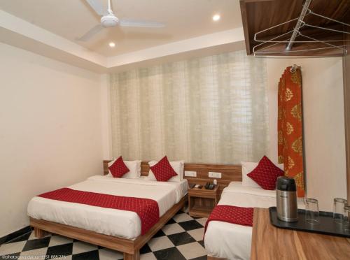 a hotel room with two beds and a table at The Uddhav Elite in Udaipur