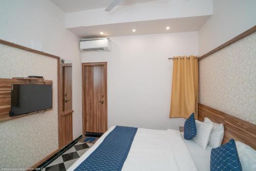 a hotel room with a bed and a television at The Uddhav Elite in Udaipur