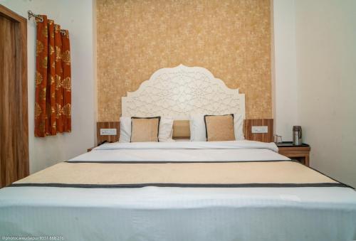 a bedroom with a large bed with a white headboard at The Uddhav Elite in Udaipur