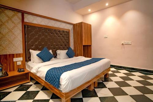 a bedroom with a large bed with a checkered floor at The Uddhav Elite in Udaipur