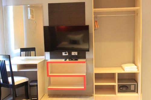 a room with a desk with a tv in it at Sumo Asia Hotels - Davao in Davao City