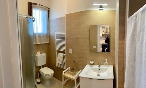 a bathroom with a sink and a toilet and a mirror at Casa Vittoria in Venice-Lido