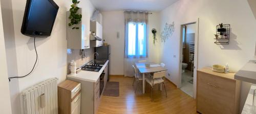 cocina y comedor con mesa y TV en Casa Vittoria en Venice-Lido