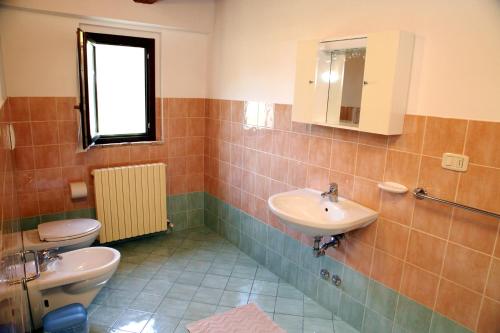 y baño con aseo y lavamanos. en Agriturismo Sant'Antonio en Montegridolfo