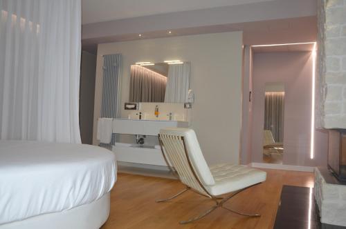 a bedroom with a white bed and a chair at Suite Testani in Frosinone