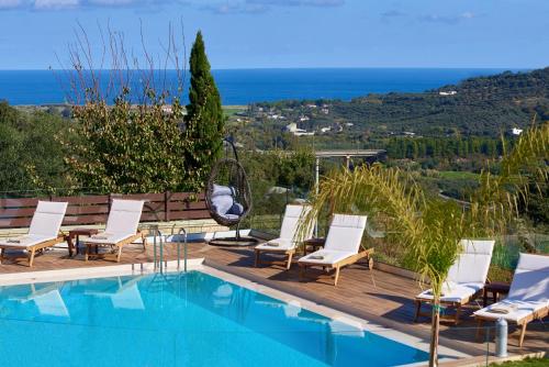a pool with chairs and a view of the ocean at Polemarchi Mystique Villa in VoukoliaÃ­