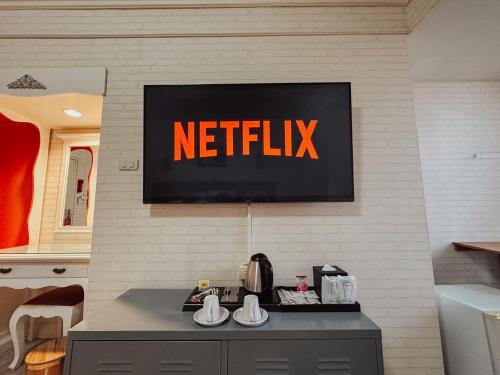 un cartel de netflix en la pared de una cocina en Hotel De Khuvieng en Chiang Mai