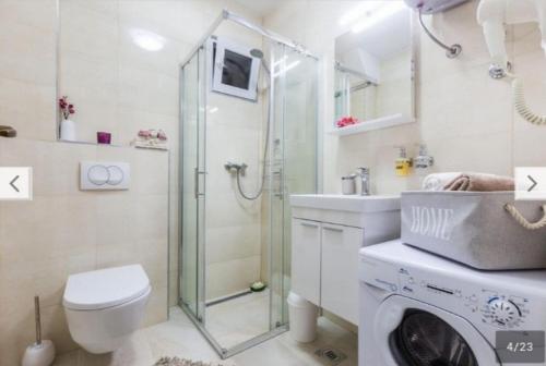 a bathroom with a shower and a washing machine at APARTMENT KAYA in Zadar