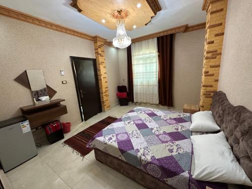 a bedroom with a bed and a chandelier at Petra View Flat in Wadi Musa