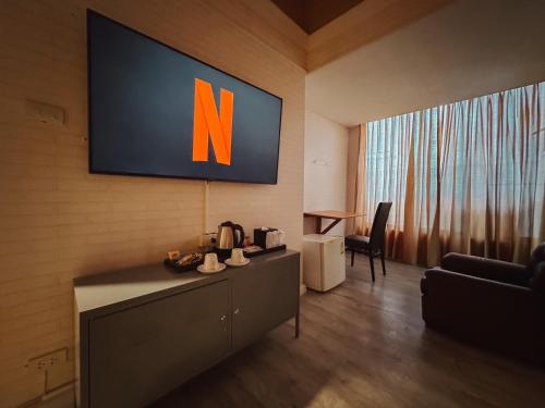 a television with the letter n on a wall at Hotel De Khuvieng in Chiang Mai