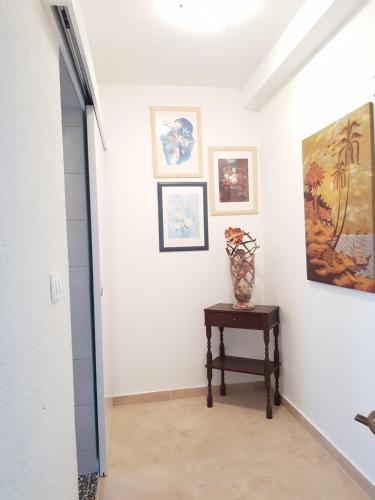 a hallway with a table and paintings on the wall at Apartments Helena Pomer in Pomer