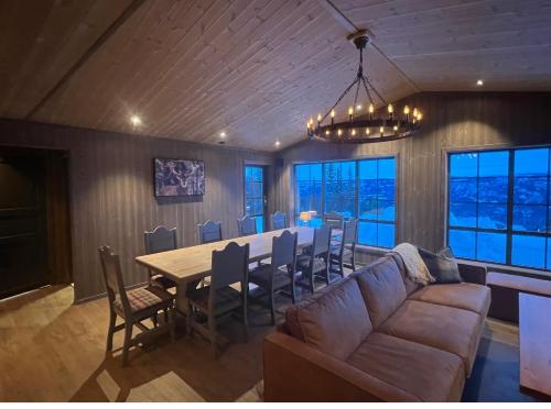 a living room with a couch and a table with chairs at Ski in/ski out i Aurdal - helt ny hytte in Aurdal