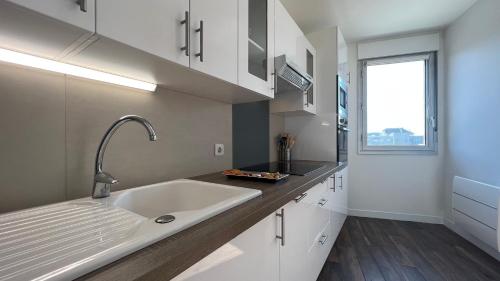 uma cozinha com um grande lavatório e uma janela em HOMEY VINTAGE - Hypercentre - Proche Gare et Tram - Terrasse privée - Wifi gratuit em Annemasse