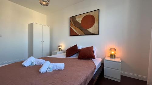 een slaapkamer met 2 bedden en een schilderij aan de muur bij HOMEY VINTAGE - Hypercentre - Proche Gare et Tram - Terrasse privée - Wifi gratuit in Annemasse