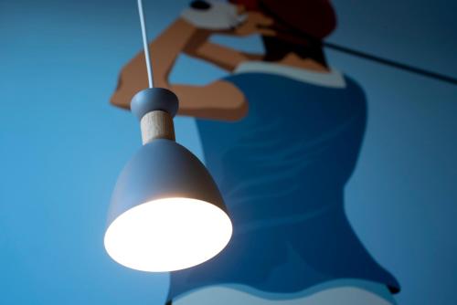 a woman in a blue dress looking at a light at Ibis Styles Le Touquet in Le Touquet-Paris-Plage