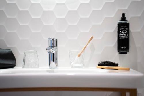 a white sink with a bottle of soap and a brush at Ibis Styles Le Touquet in Le Touquet-Paris-Plage