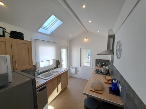 une cuisine avec un comptoir, un évier et une fenêtre dans l'établissement Villa des Thermes, St Jean d'Angély, à Saint-Jean-dʼAngély