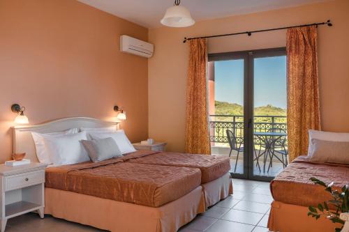 a hotel room with two beds and a balcony at Crystal Palace - Luce in Skala Kefalonias