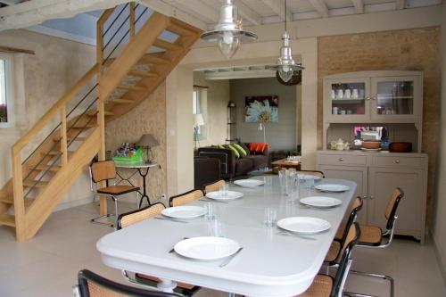 jadalnia z białym stołem i krzesłami w obiekcie Maison Bel'Air Bayeux w mieście Vaucelles