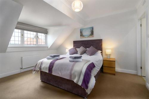 a bedroom with a large bed and a window at Crannog Cottage in Llandudno