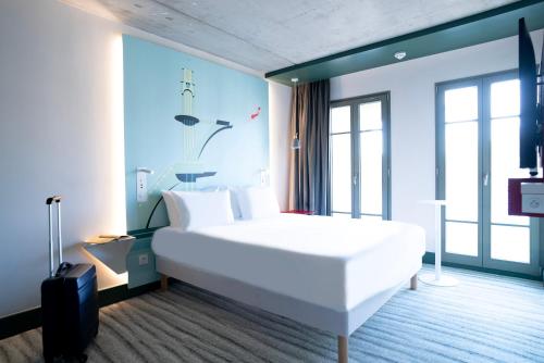 sypialnia z dużym białym łóżkiem w pokoju w obiekcie Ibis Styles Le Touquet w mieście Le Touquet-Paris-Plage