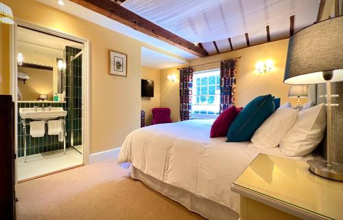 a bedroom with a bed and a bathroom with a sink at The Kings Head in Dorking
