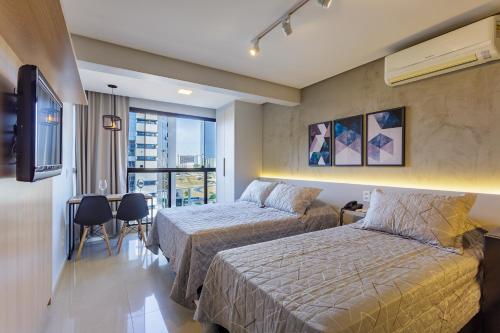 a hotel room with two beds and a balcony at Apart Hotel Centro de Brasília - Garvey Park Hotel in Brasilia