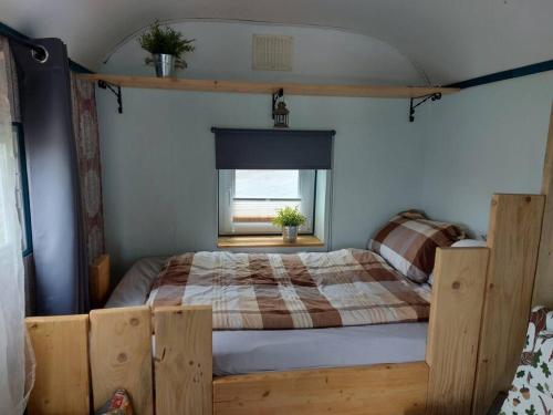 ein Schlafzimmer mit einem Holzbett und einem Fenster in der Unterkunft GeraldineWeg30- Bauwagenflair in Hessisch Oldendorf