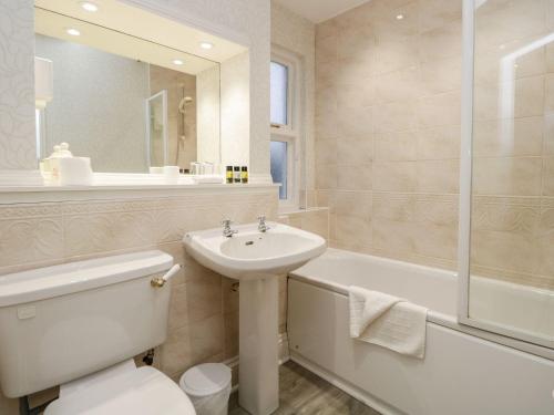 a bathroom with a sink and a toilet and a tub at Valley View in Dalton in Furness