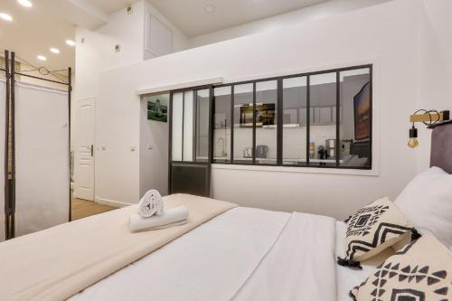 - une chambre avec un lit blanc et une fenêtre dans l'établissement 05 - Parisian Design Loft, à Paris