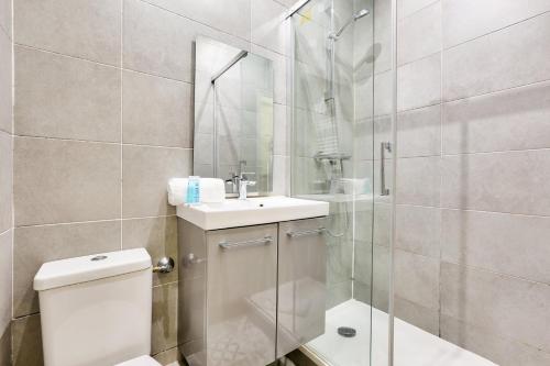 La salle de bains est pourvue de toilettes, d'un lavabo et d'une douche. dans l'établissement 05 - Parisian Design Loft, à Paris