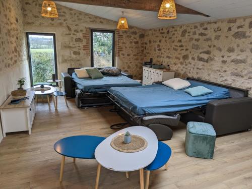 Habitación con 2 camas, mesa y sillas en Maison de Vacances 12min du Puy du fou grand studio, en Saint-Laurent-sur-Sèvre