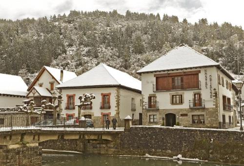 a group of buildings on a bridge over a river at Hostal Orialde in Ochagavía