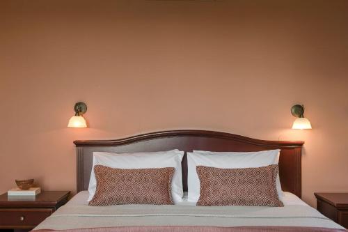 a bedroom with a bed with two lamps on the wall at Crystal Palace - Luce in Skala Kefalonias