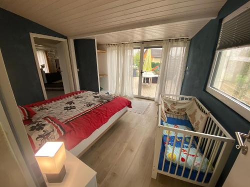 a bedroom with a bed and a crib in it at Super appart piscine proche Genève in Viry