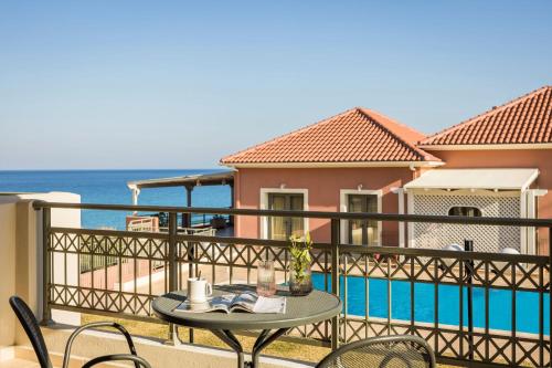 a table on a balcony with a view of the ocean at Crystal Palace - Luce in Skala Kefalonias