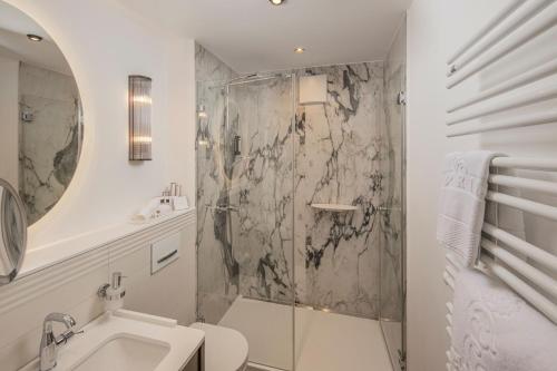 La salle de bains est pourvue d'une douche, de toilettes et d'un lavabo. dans l'établissement Hotel-Restaurant Erbprinz, à Ettlingen