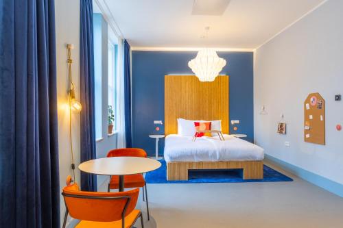 a bedroom with a bed and a table and chairs at Vie Via - Your Hotel in Leeuwarden