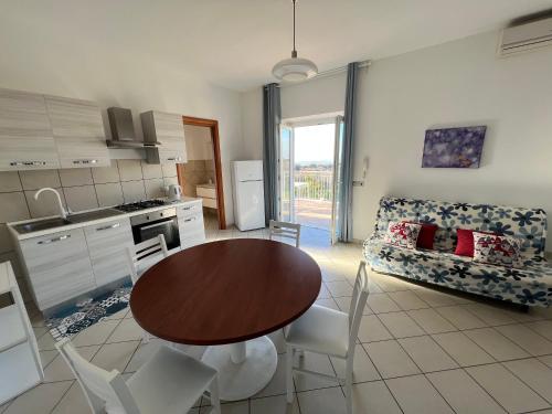 a kitchen and living room with a table and chairs at La Terrazza Sul Ciliegio in Marino