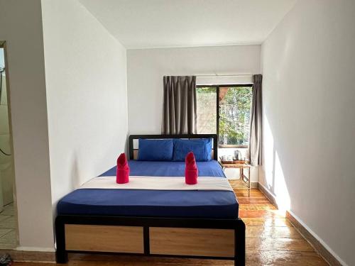 a bedroom with a bed with red pillows on it at Happy Elephant Bungalows in Koh Rong Island