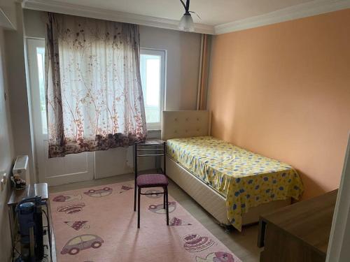 a bedroom with a bed and a chair and a window at Apartmen in Mudanya in Mudanya