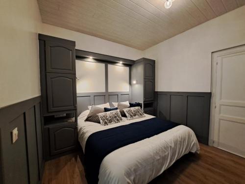 een slaapkamer met een groot bed met een zwart hoofdeinde bij Villa des Thermes, St Jean d'Angély in Saint-Jean-dʼAngély