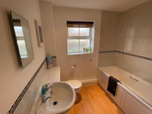 La salle de bains est pourvue d'un lavabo, de toilettes et d'une baignoire. dans l'établissement 2 Bedroom Ground Floor Flat, à Haddenham
