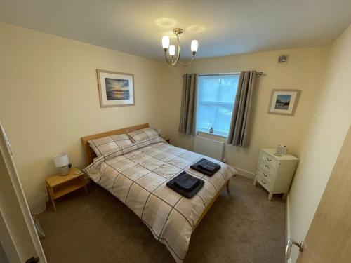 a bedroom with a bed with two towels on it at 2 Bedroom Ground Floor Flat in Haddenham