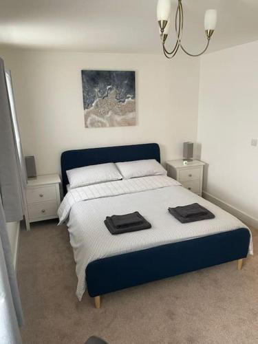 a bedroom with a large bed with two night stands at 2 Bedroom Ground Floor Flat in Haddenham
