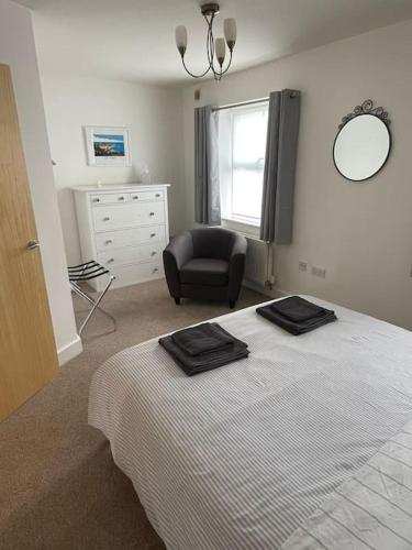 a bedroom with a bed with a chair and a dresser at 2 Bedroom Ground Floor Flat in Haddenham