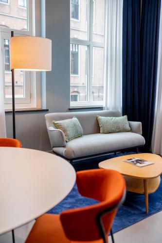 a living room with a couch and a table and chairs at Vie Via - Your Hotel in Leeuwarden